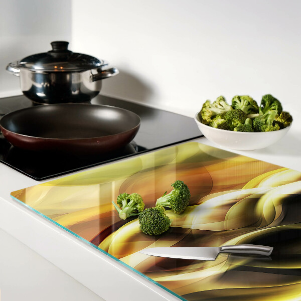 Tagliere in vetro con decorazione a onde astratte nei toni dell'oro