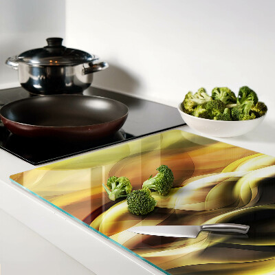 Tagliere in vetro con decorazione a onde astratte nei toni dell'oro