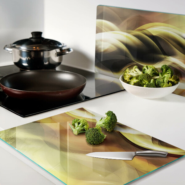 Tagliere in vetro con decorazione a onde astratte nei toni dell'oro