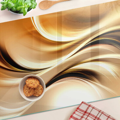Tagliere in vetro con decorazione a onde astratte nei toni dell'oro