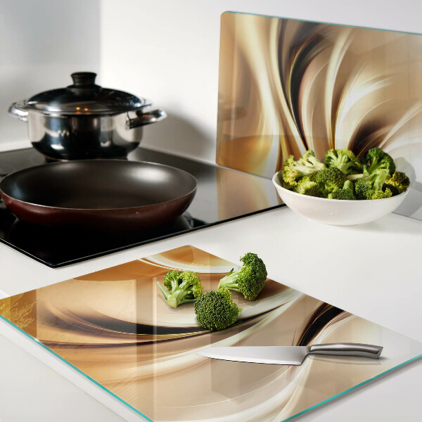 Tagliere in vetro con decorazione a onde astratte nei toni dell'oro