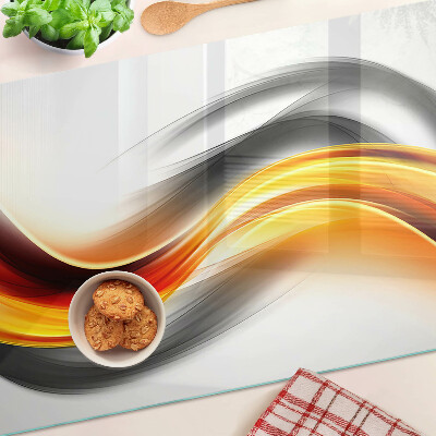 Tagliere in vetro temperato con motivo a onde nei toni dell'arancione e del nero