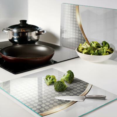 Tagliere in vetro temperato con motivo a onda dorata su sfondo a pois