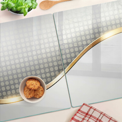 Tagliere in vetro temperato con motivo a onda dorata su sfondo a pois