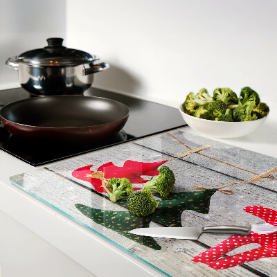 Tagliere in vetro temperato con decorazioni natalizie su sfondo di legno