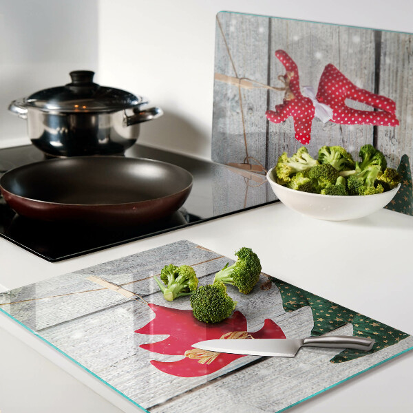 Tagliere in vetro temperato con decorazioni natalizie su sfondo di legno