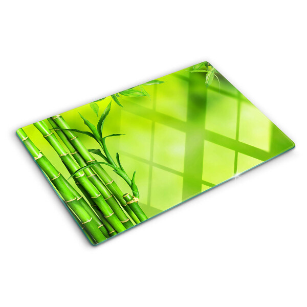 Tagliere in vetro temperato con superficie in bambù su sfondo verde