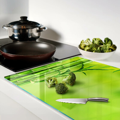 Tagliere in vetro temperato con superficie in bambù su sfondo verde