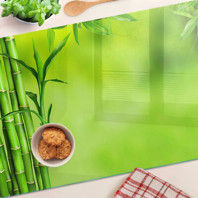 Tagliere in vetro temperato con superficie in bambù su sfondo verde