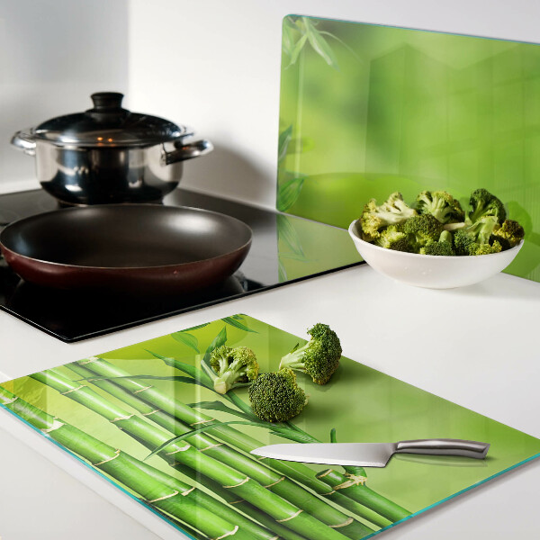 Tagliere in vetro temperato con superficie in bambù su sfondo verde