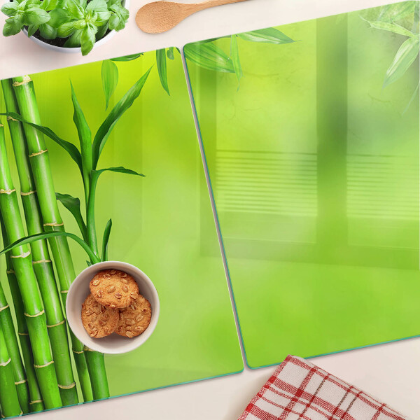 Tagliere in vetro temperato con superficie in bambù su sfondo verde