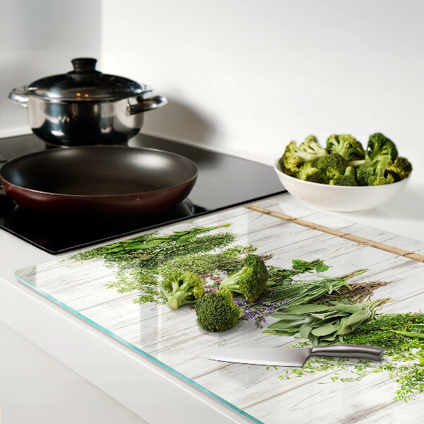 Tagliere in vetro temperato con decorazione di erbe su sfondo di legno