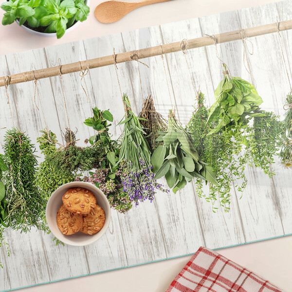Tagliere in vetro temperato con decorazione di erbe su sfondo di legno