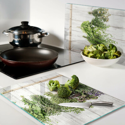 Tagliere in vetro temperato con decorazione di erbe su sfondo di legno