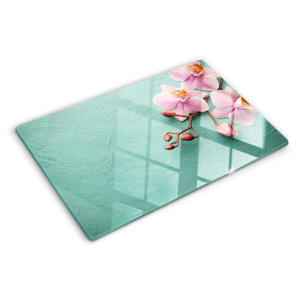 Tagliere in vetro con stampa di orchidee su sfondo blu