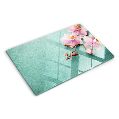 Tagliere in vetro con stampa di orchidee su sfondo blu