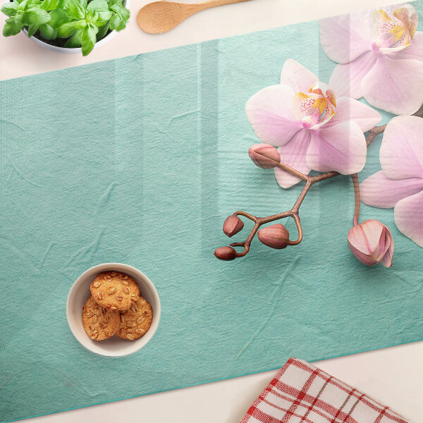 Tagliere in vetro con stampa di orchidee su sfondo blu