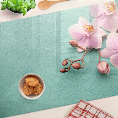 Tagliere in vetro con stampa di orchidee su sfondo blu