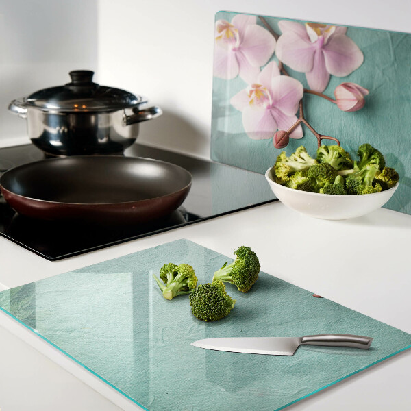 Tagliere in vetro con stampa di orchidee su sfondo blu