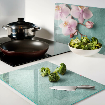 Tagliere in vetro con stampa di orchidee su sfondo blu