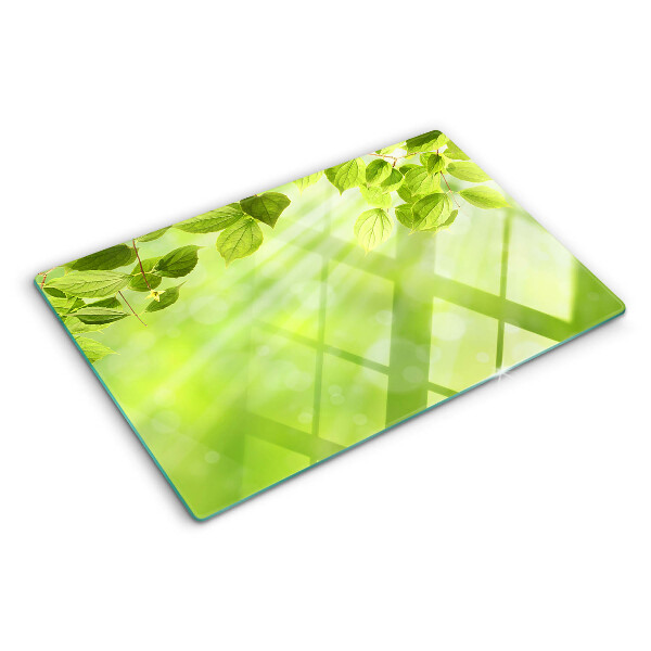 Tagliere in vetro con motivo di foglie verdi su sfondo chiaro