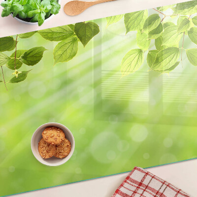 Tagliere in vetro con motivo di foglie verdi su sfondo chiaro