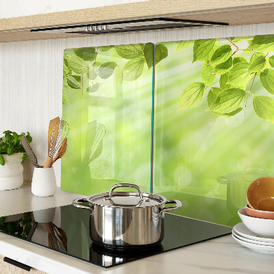 Tagliere in vetro con motivo di foglie verdi su sfondo chiaro