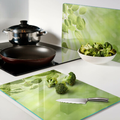 Tagliere in vetro con motivo di foglie verdi su sfondo chiaro