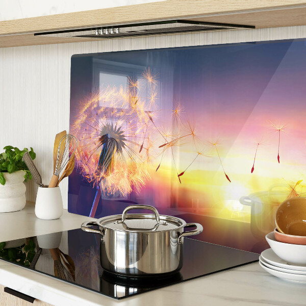 Tagliere in vetro temperato con motivo di denti di leone sullo sfondo di un tramonto