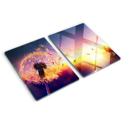 Tagliere in vetro temperato con motivo di denti di leone sullo sfondo di un tramonto