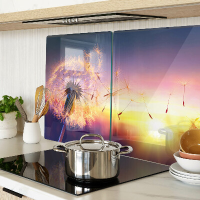 Tagliere in vetro temperato con motivo di denti di leone sullo sfondo di un tramonto