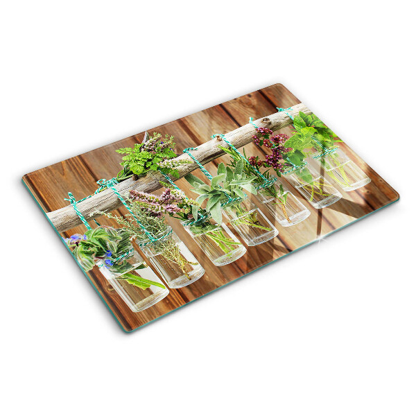 Tagliere in vetro temperato con motivo di erbe in barattoli su sfondo di legno