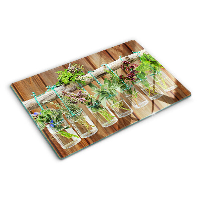 Tagliere in vetro temperato con motivo di erbe in barattoli su sfondo di legno