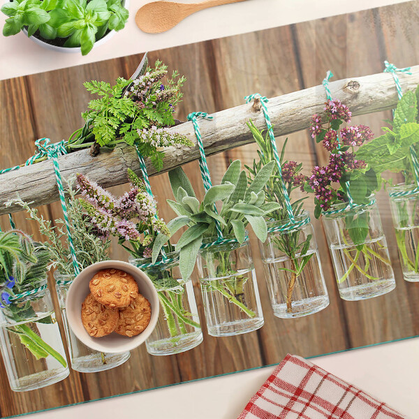 Tagliere in vetro temperato con motivo di erbe in barattoli su sfondo di legno