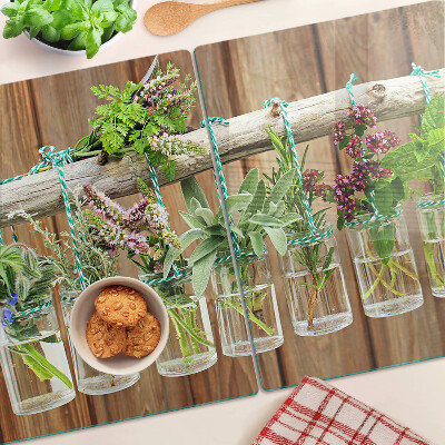 Tagliere in vetro temperato con motivo di erbe in barattoli su sfondo di legno