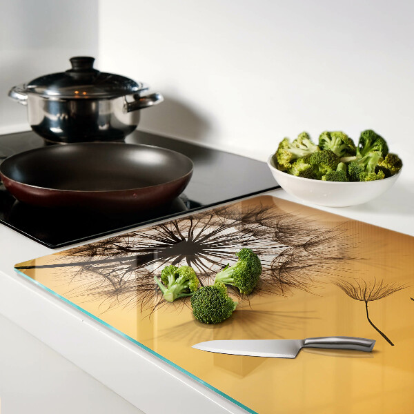 Tagliere in vetro temperato con motivo di denti di leone sullo sfondo di un tramonto