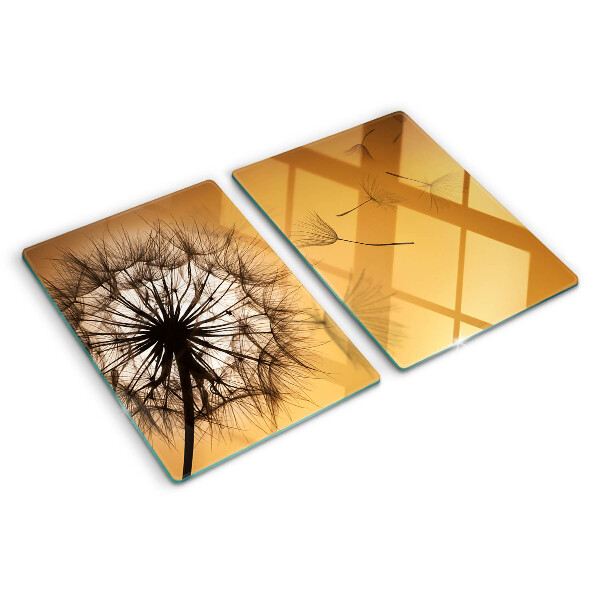 Tagliere in vetro temperato con motivo di denti di leone sullo sfondo di un tramonto