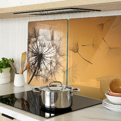 Tagliere in vetro temperato con motivo di denti di leone sullo sfondo di un tramonto