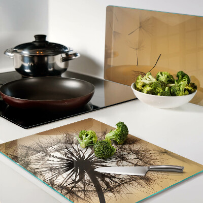 Tagliere in vetro temperato con motivo di denti di leone sullo sfondo di un tramonto