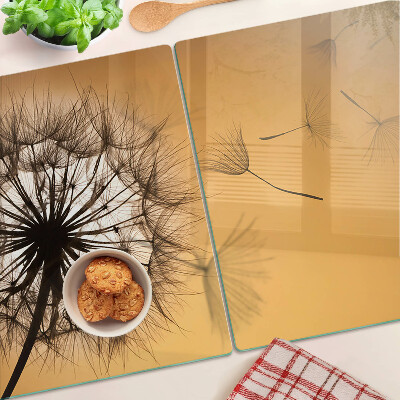 Tagliere in vetro temperato con motivo di denti di leone sullo sfondo di un tramonto