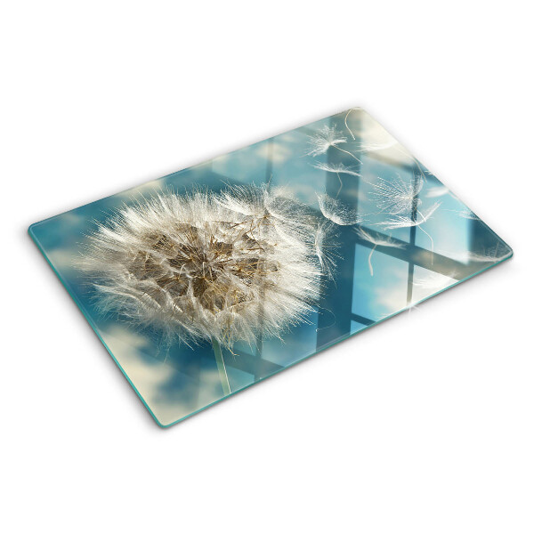 Tagliere in vetro con motivo di denti di leone su sfondo azzurro