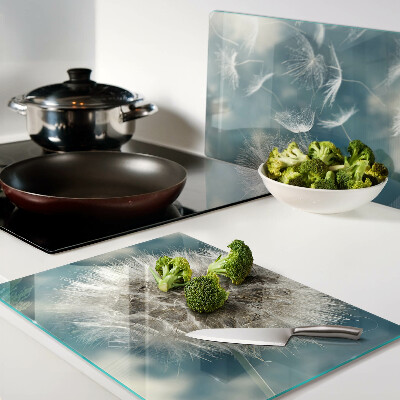 Tagliere in vetro con motivo di denti di leone su sfondo azzurro