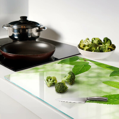 Tagliere in vetro temperato con motivo di foglie su sfondo verde sfocato