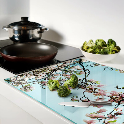 Tagliere in vetro con motivo di fiori di magnolia su sfondo blu