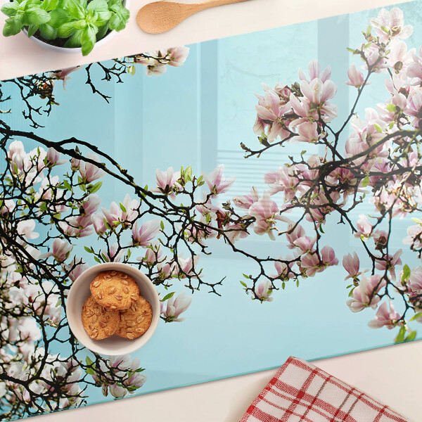 Tagliere in vetro con motivo di fiori di magnolia su sfondo blu