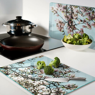 Tagliere in vetro con motivo di fiori di magnolia su sfondo blu