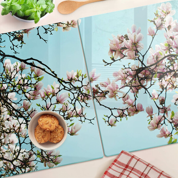 Tagliere in vetro con motivo di fiori di magnolia su sfondo blu