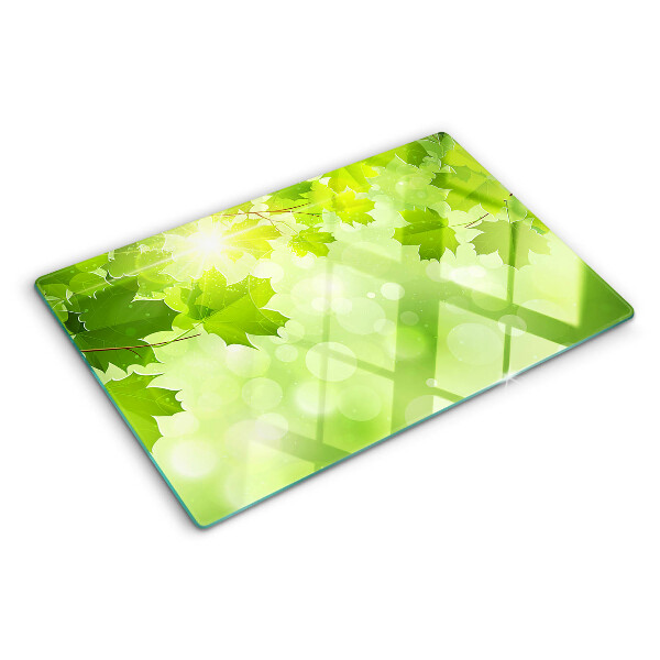 Tagliere in vetro temperato con motivo di foglie illuminate dai raggi del sole