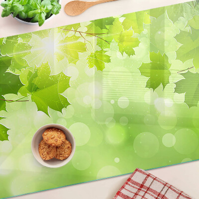 Tagliere in vetro temperato con motivo di foglie illuminate dai raggi del sole