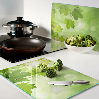 Tagliere in vetro temperato con motivo di foglie illuminate dai raggi del sole